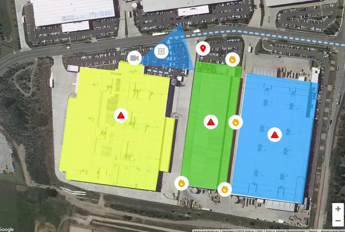 Satellite map of an industrial site with warehouses highlighted in colour, hazard and fire markers, and a dotted access route
