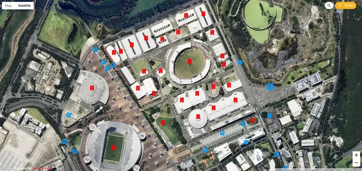 Satellite map of the Sydney Showground precinct with red venue pins and blue transport and parking pins