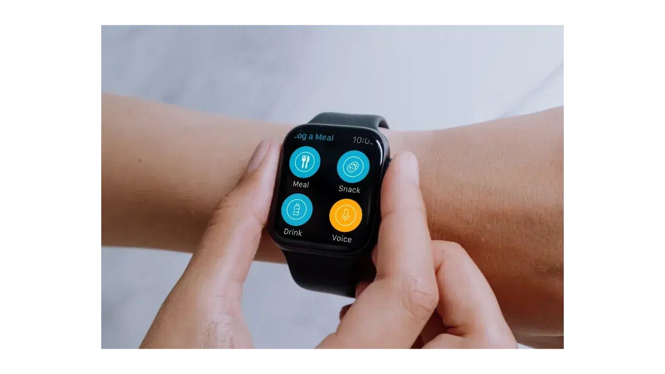 Hands tapping an Apple Watch that shows meal, snack, drink and voice logging buttons