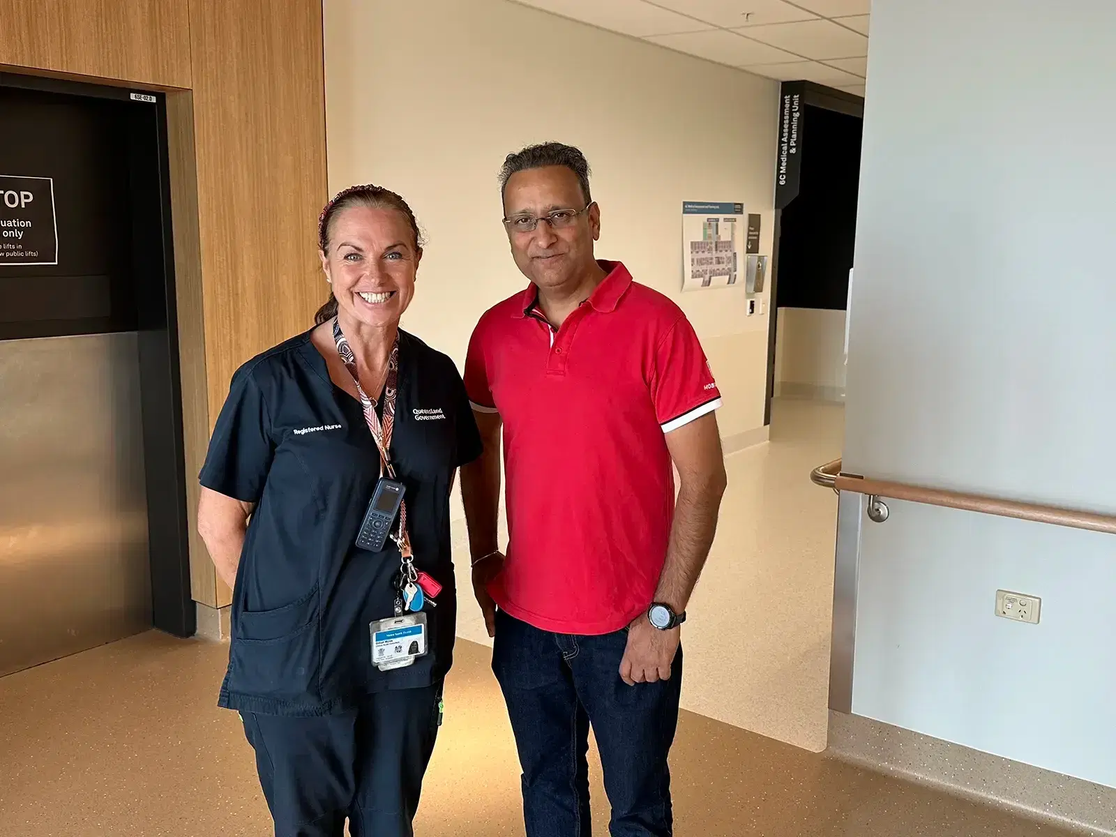 A registered nurse and Mobiddiction founder Mike Vasavada standing together in a hospital corridor