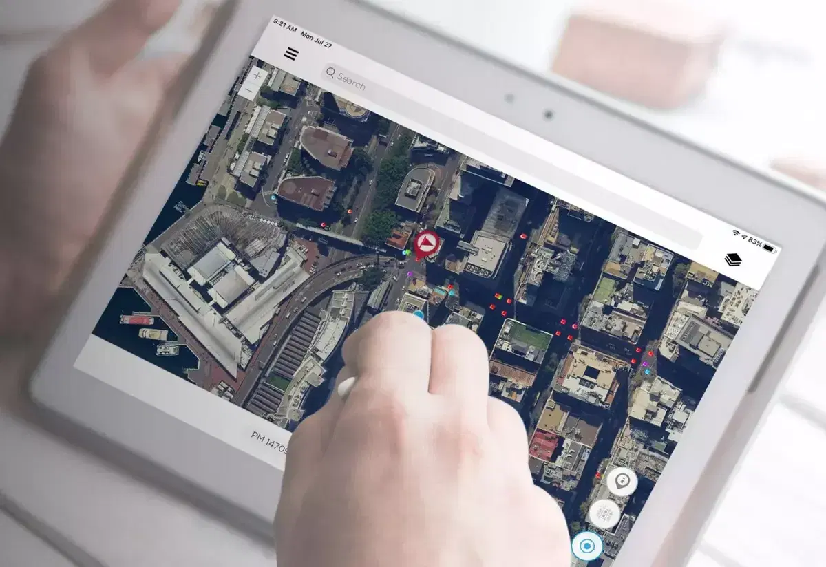 Surveyor using the Survey Mark app on a tablet, with survey mark pins over aerial imagery