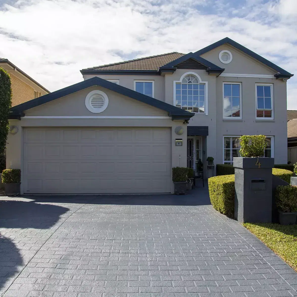 Front of a two-storey house with a double garage and a paved driveway