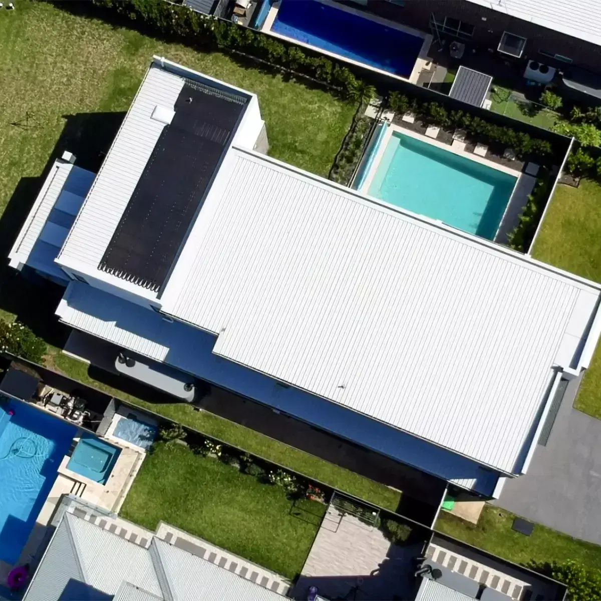 Drone view looking straight down on a modern house with rooftop solar panels and a backyard pool